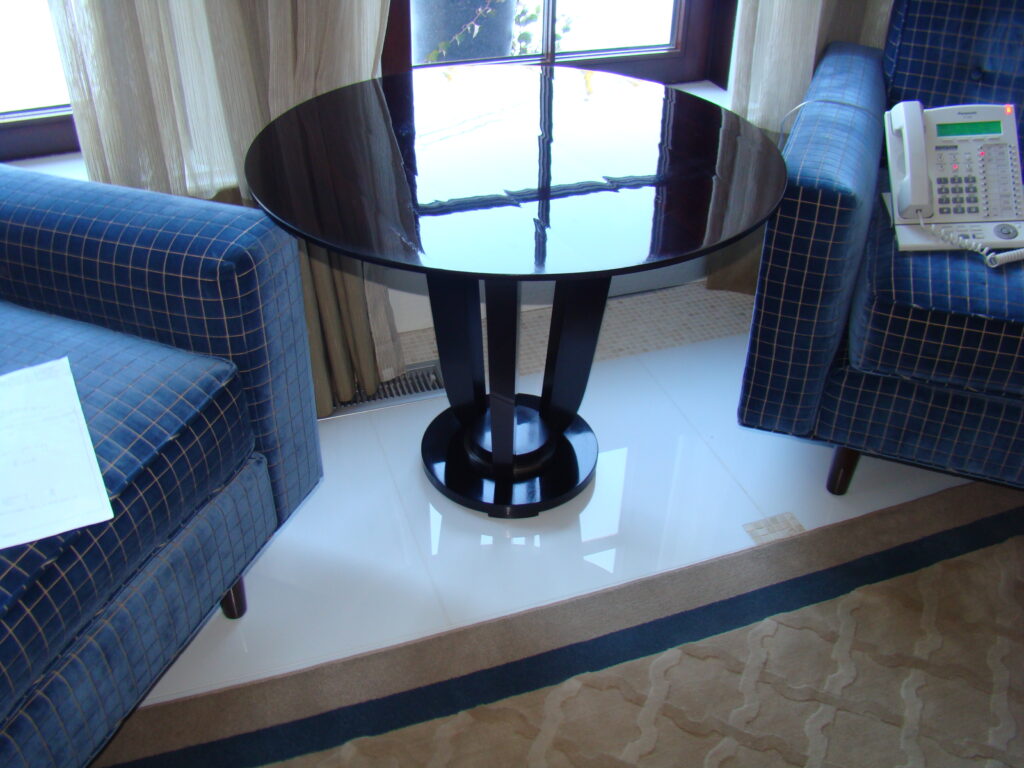 Barbara Barry round end table (BA3457) — restored high-gloss mahogany surface reflecting window and natural light.