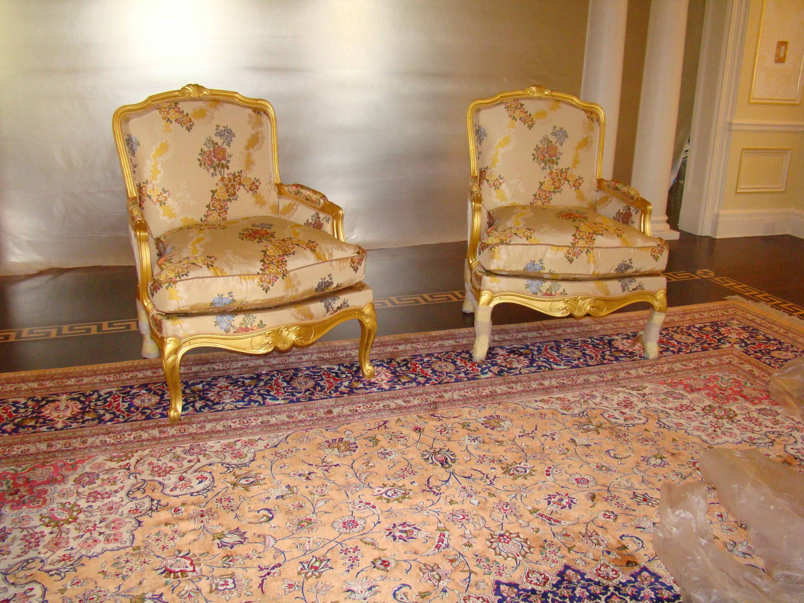 Pair of Baker French‑style chairs with silk upholstery, photographed in the client’s home after delivery.
