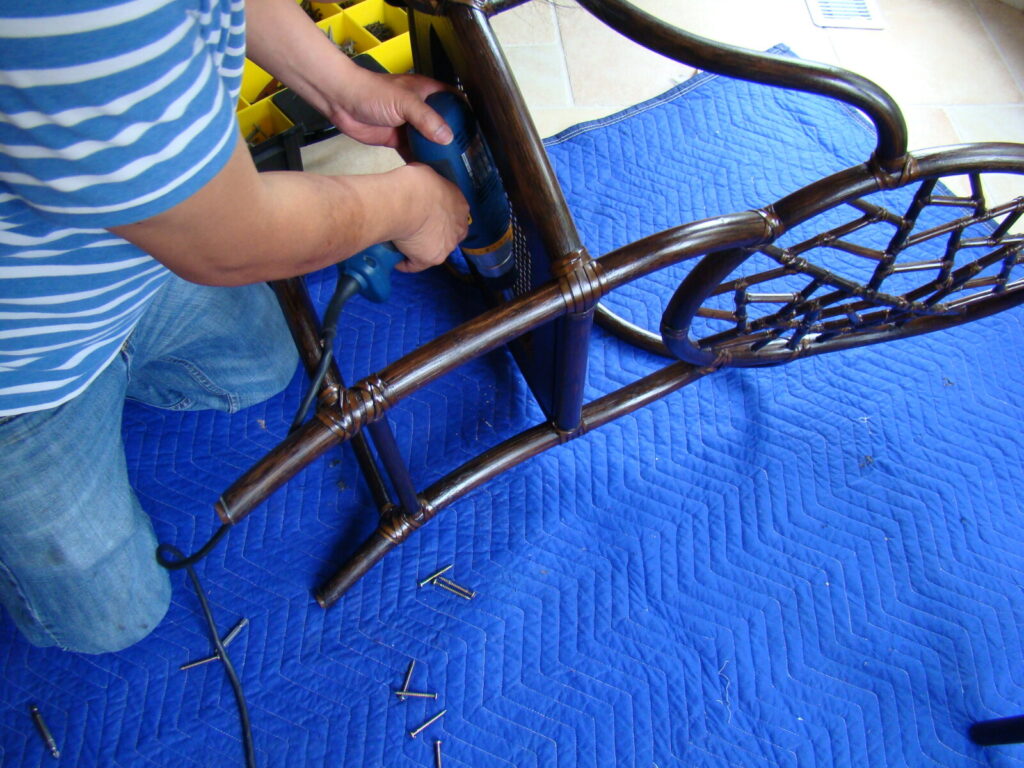 Technician repairing a wooden dining chair on-site in the client’s home.