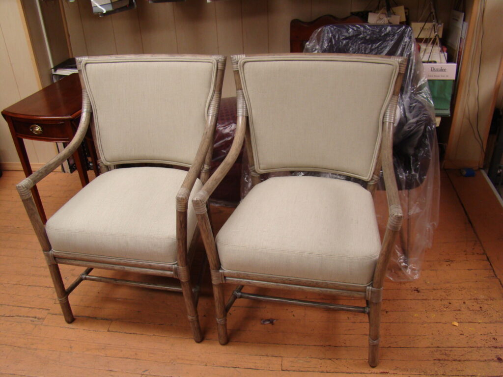 Fully restored McGuire rattan armchair with refinished frame and new custom upholstery, showing in room