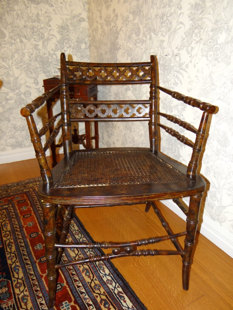 Antique wooden armchair with a carved backrest and caned seat