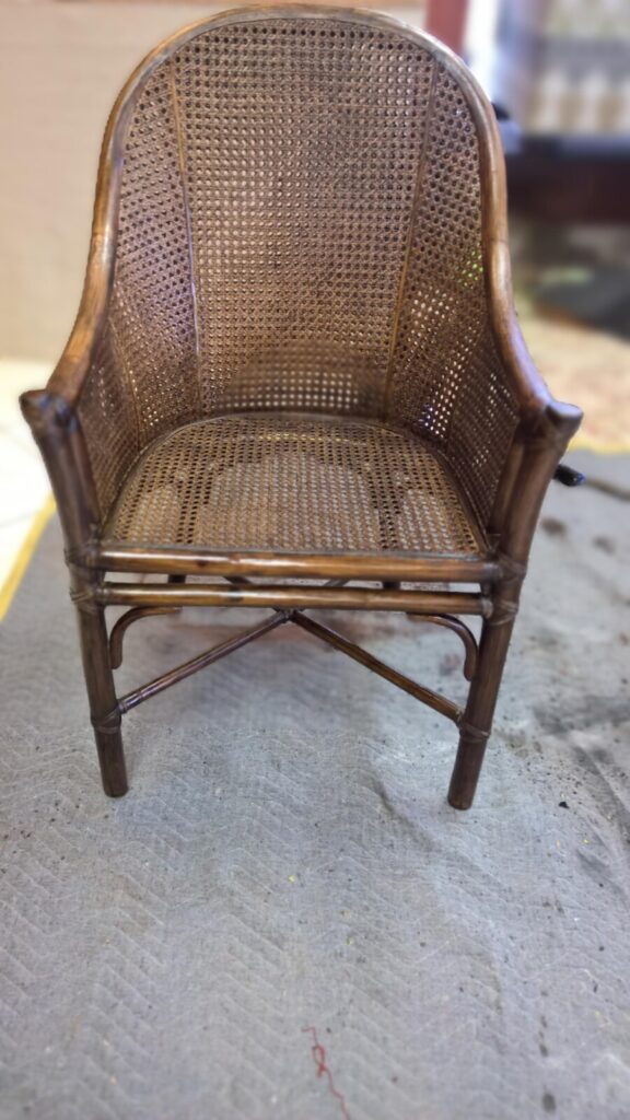 Restored McGuire cane‑panel armchair with new cane installed and the frame refinished after the restoration process.