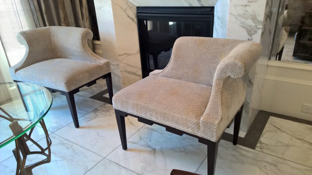 Luxury restoration of Baker castle corner chairs showcasing precision upholstery and artisan furniture refinishing for high-value classic collections.