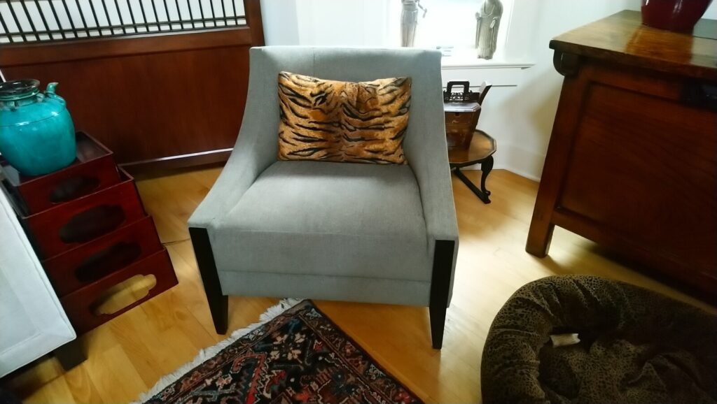 Restored Baker upholstered armchair featuring a contemporary silhouette and premium textured gray fabric, shown after delivery in a modern residential setting.