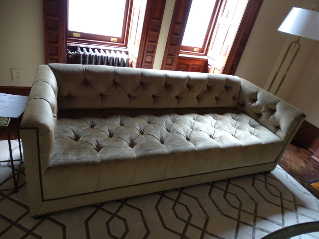 Restored Baker Paris sofa featuring deep diamond tufting on the interior back and seat, upholstered in a luxurious champagne gold velvet with a hand-applied nailhead trim along the base.