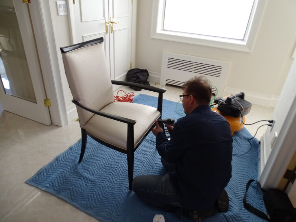Repairing a chair in the client’s home during an on‑site restoration visit.