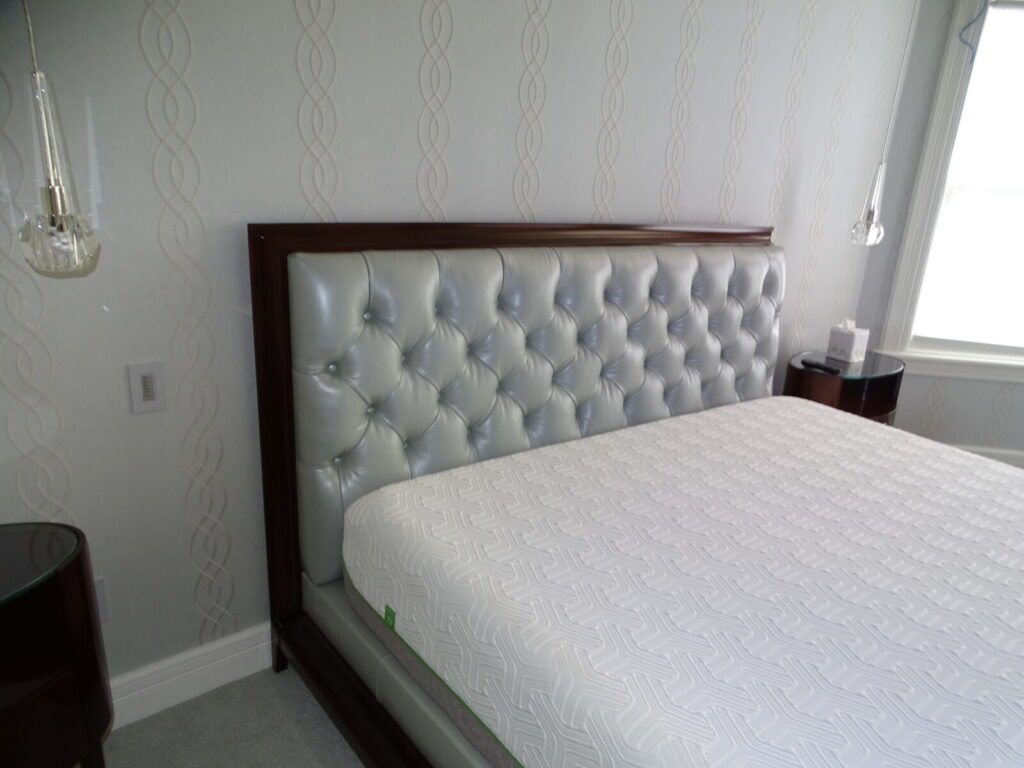 Platform king bed with a tufted upholstered headboard shown after delivery in a finished interior.