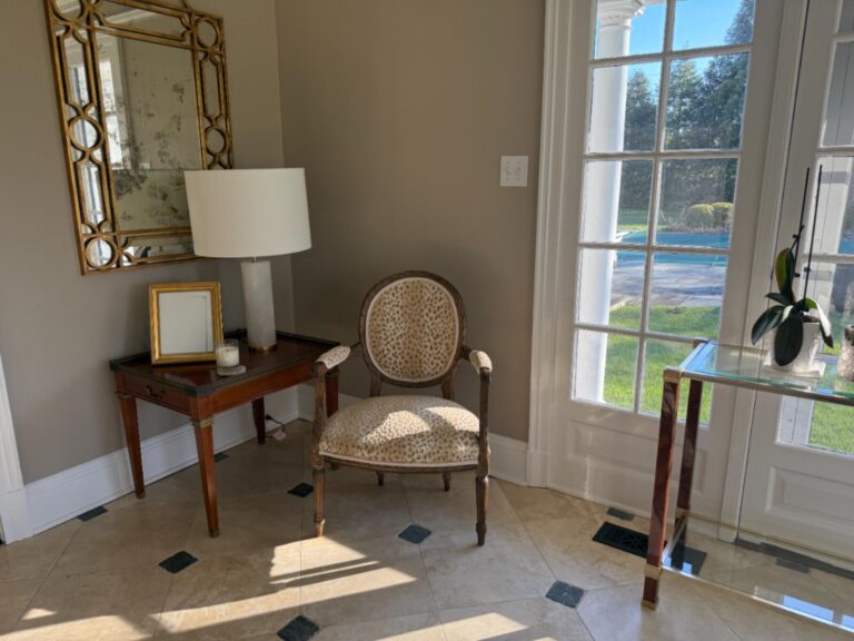 Luxury baker furniture restoration showcasing artisan upholstery and wood refinishing for a highend residential interior with views of a private garden and pool.
