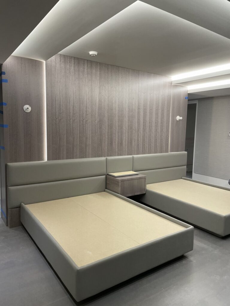 Custom headboard and bed frame with led lighting, mirrors, and mahogany wood trim.