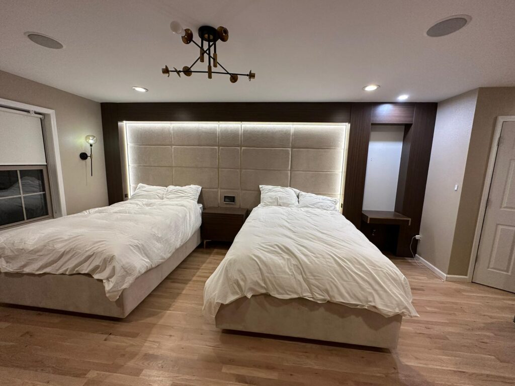 Modern suite featuring horizontal upholstered wall panels with integrated lighting and high-gloss wood built-ins.