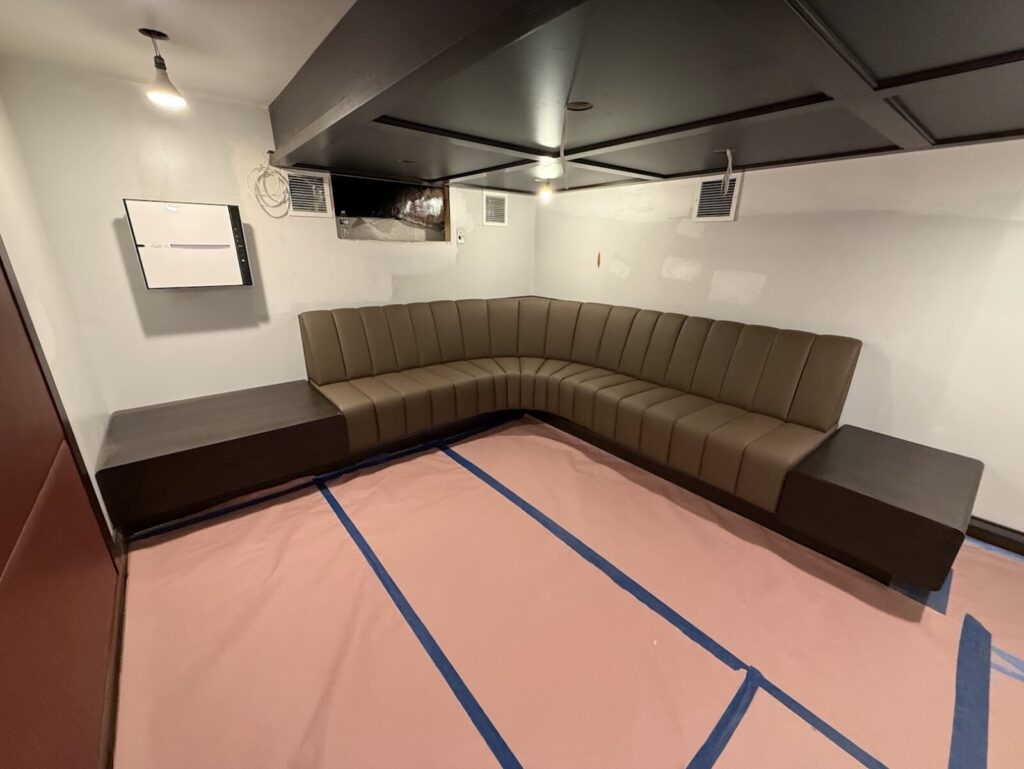 Vertical channel banquette with firm seat and recessed base detail.