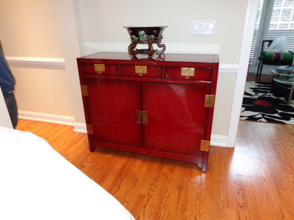 Baker red lacquer chinoiserie cabinet restored with brass hardware detailing.