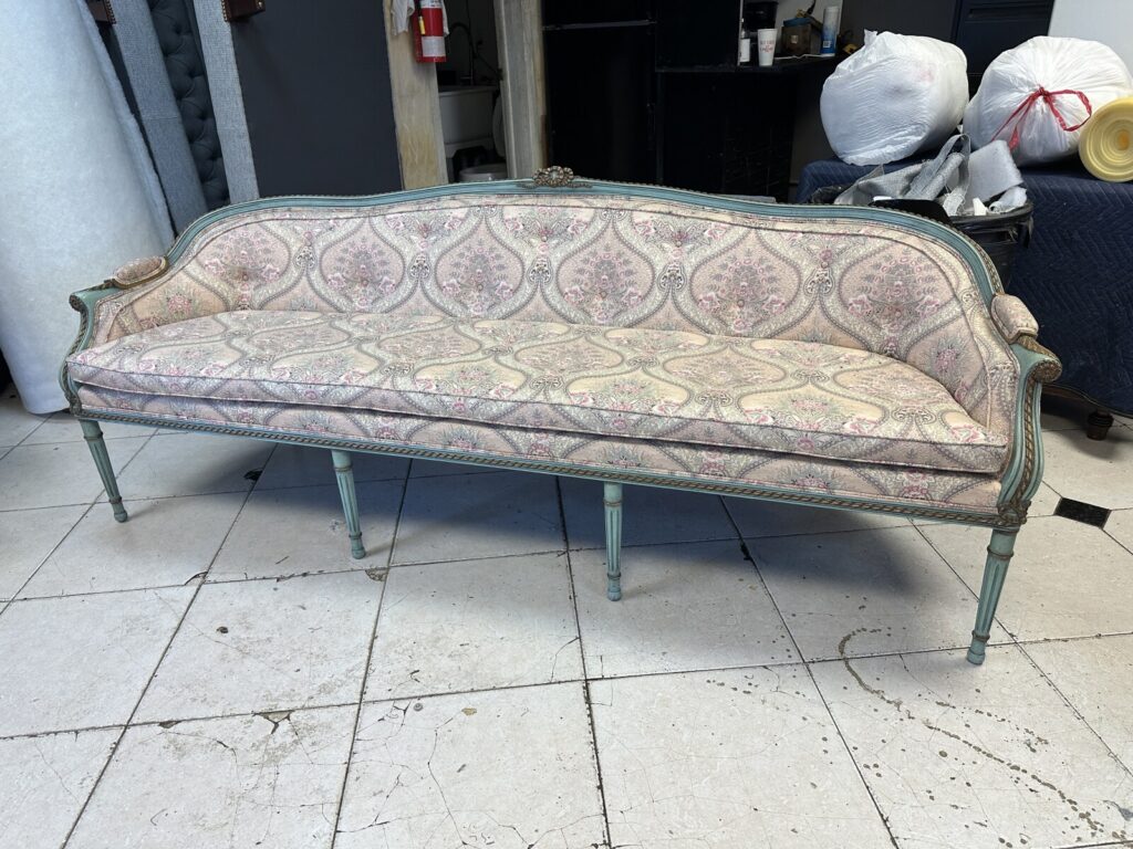 Antique Louis XVI canape sofa shown in the workshop before refinishing and reupholstery.