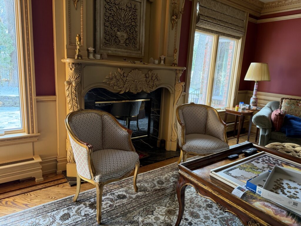 Pair of antique gold leaf chairs restored and reupholstered, shown after delivery in a completed interior.
