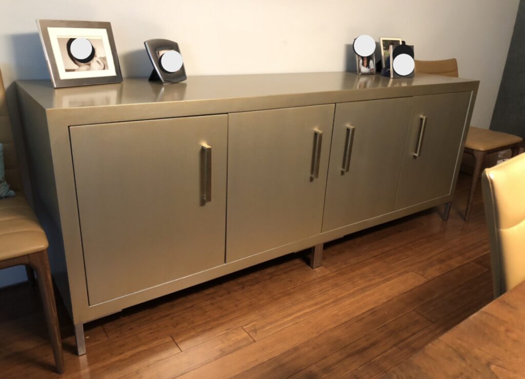 Refinished Baker sideboard photographed in the client’s home after delivery, showing the restored antique gold exterior and light‑blue interior.