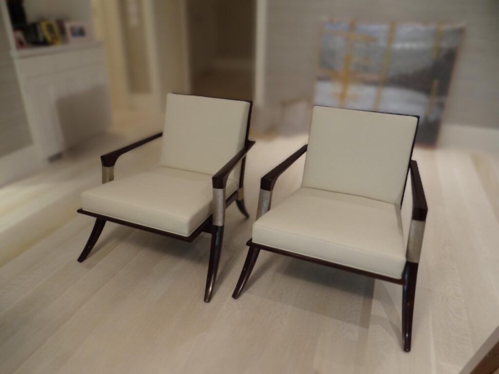 Pair of lounge chairs refinished and reupholstered, shown after completion in a finished interior.