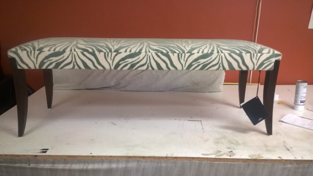 Luxury Baker Atelier bench reupholstery showcasing precision pattern matching and artisan furniture restoration for high-value classic collections.