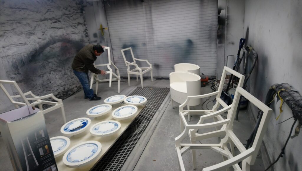 Craftsman working on Baker Thomas Pheasant chairs in the spray room during the refinishing process.