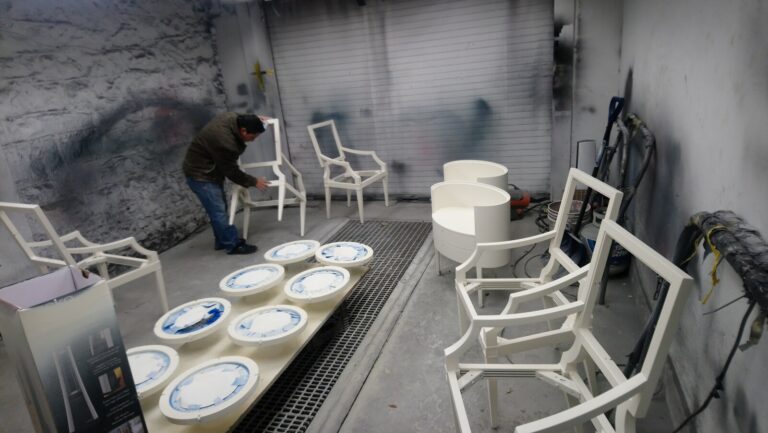 Craftsman working on Baker Thomas Pheasant chairs in the spray room during the refinishing process.
