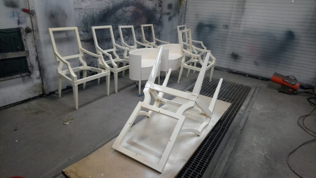 Baker Thomas Pheasant chairs lined up in the refinishing room, showing the full set in progress before completion.