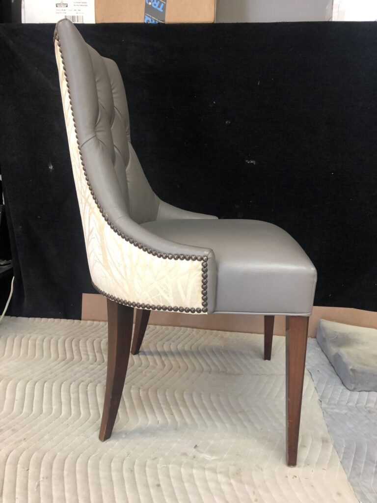 Side view of a fully reupholstered lounge chair photographed in the workshop after completion.