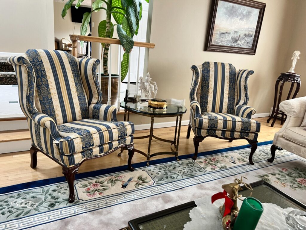 Wing chair reupholstered and shown after delivery in a completed interior.