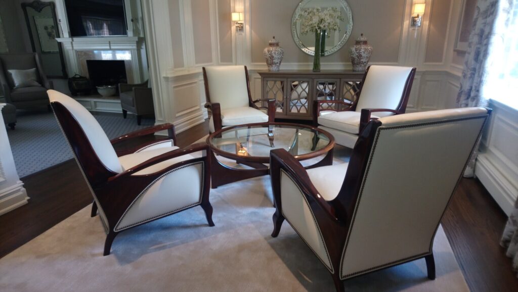 Set of four lounge chairs refinished and reupholstered, shown after delivery in a completed interior.