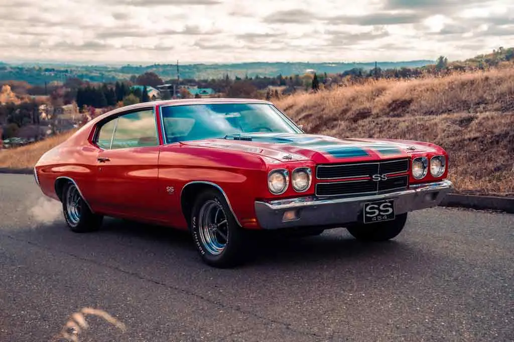Vintage muscle car restoration featuring a red Chevrolet Chevelle SS with custom interior potential and high-performance styling.