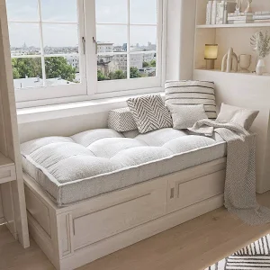 Tufted window‑seat cushion with decorative pillows arranged on a built‑in banquette.