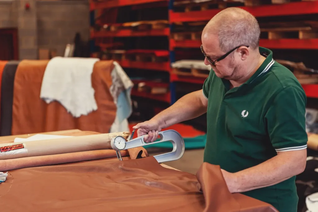 Team member cutting leather for commercial seating upholstery