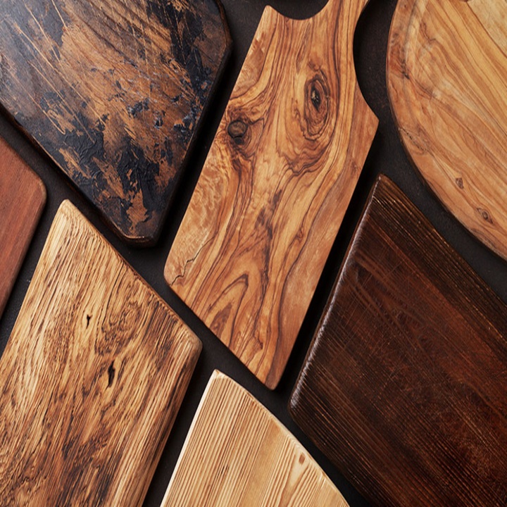 Assorted finished wooden boards in different shapes and grain patterns arranged on a flat surface.