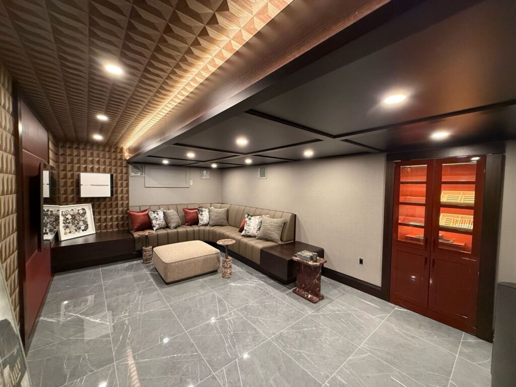 Finished home theater with custom lounge seating and large channeled banquettes, completed with full acoustic wall paneling.