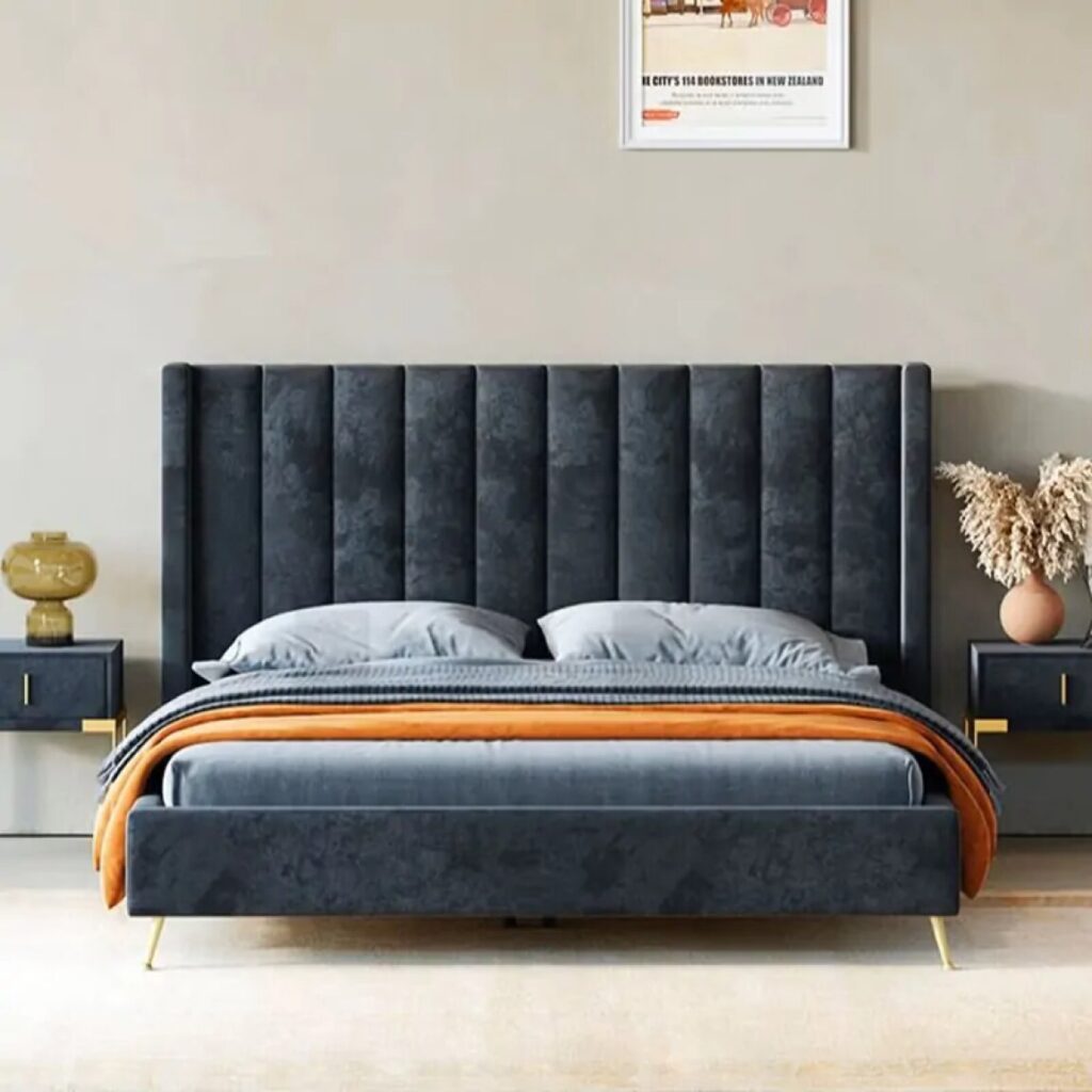 Navy blue velvet shelter‑style bed frame with winged headboard shown in a furnished bedroom with nightstands.
