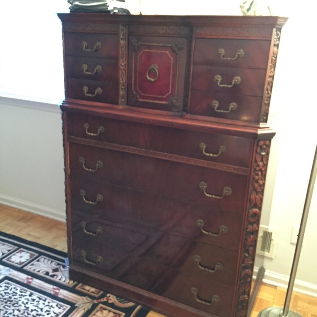 Vintage Baker tall chest in the client’s home showing wear and surface damage before restoration.