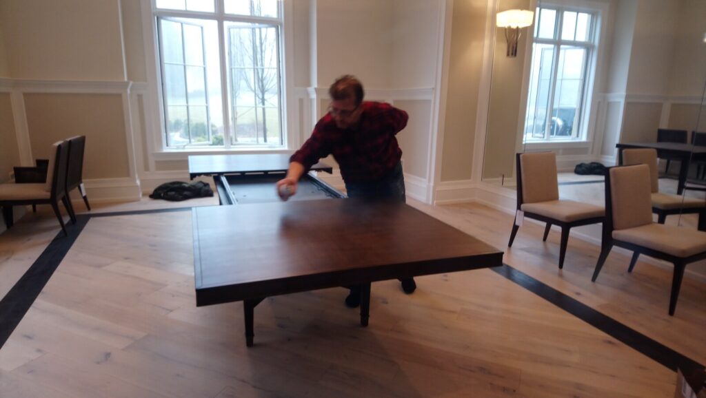 Barbara Barry for Baker Larchmont extension dining table undergoing an even spray‑coat application as part of the refinishing work.
