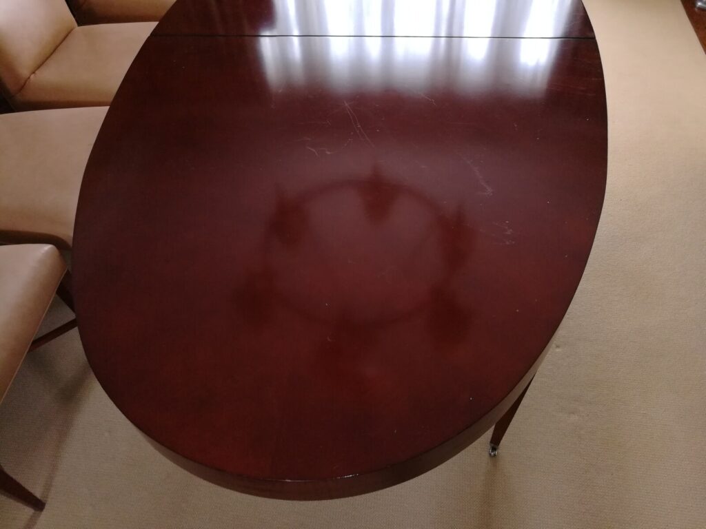 Barbara Barry for Baker oval dining table in the client’s home showing surface damage before refinishing.
