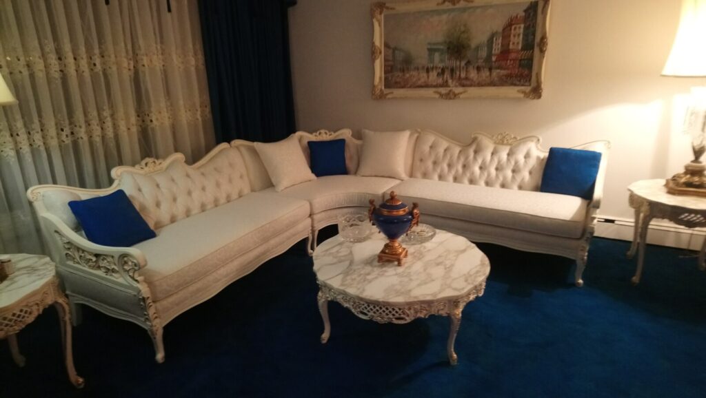 Restored sectional sofa with gold leaf detailing photographed in the client’s home after delivery.