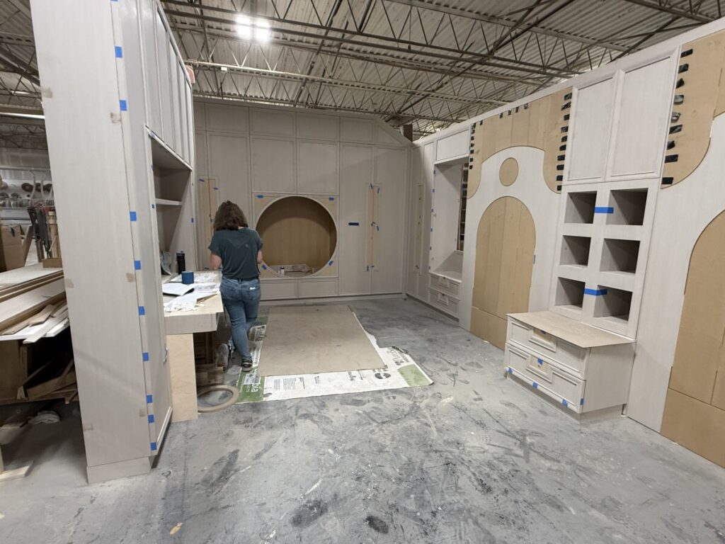Full-scale dry fit of a circular upholstered wall panel unit and custom cabinetry in the West Nyack shop.