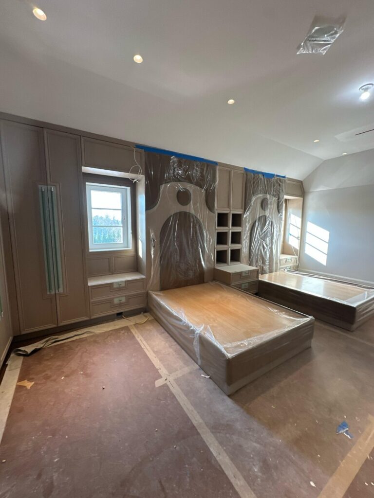 Ornate pink arched millwork with matching fabric wall panel inserts and upholstered twin beds and headboards.