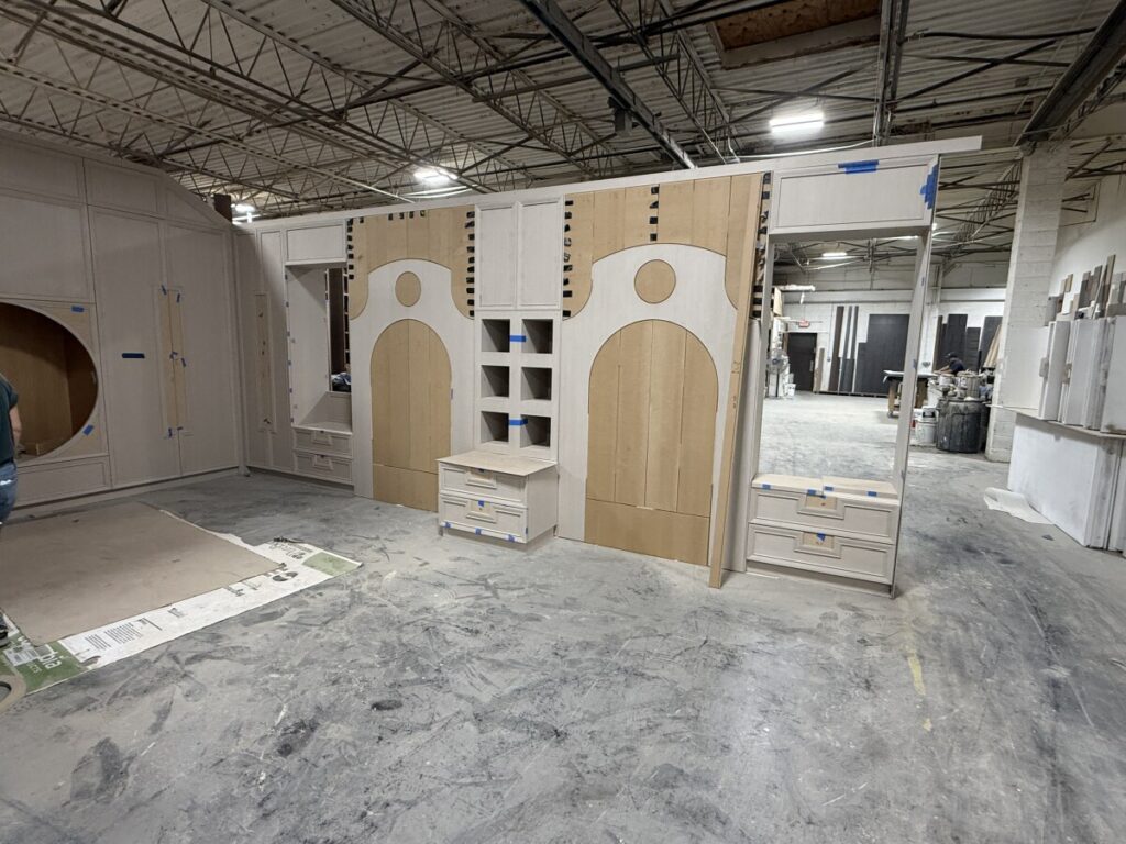 Master craftsman assembling custom wall panel and bed frame templates in the First Class MasterCraft factory.