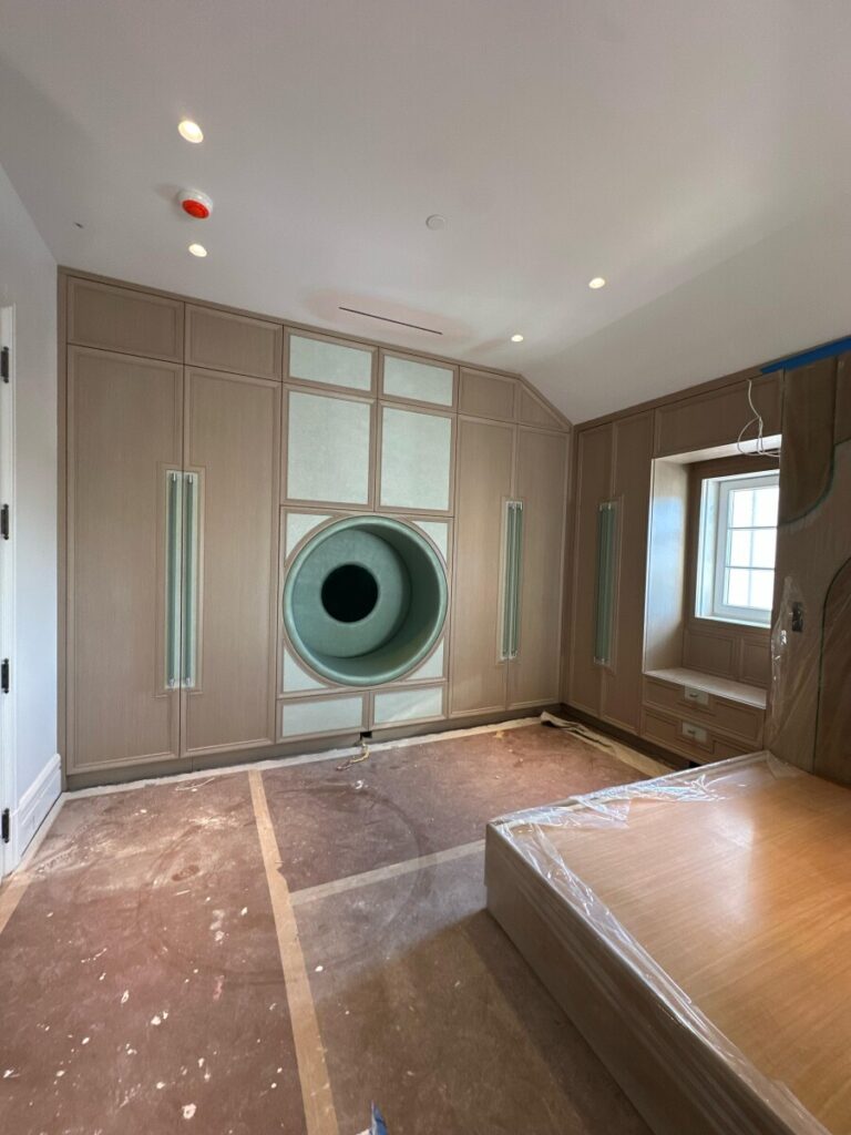 Arched velvet wall panels and custom nightstands fully mounted within the integrated wall unit during installation.