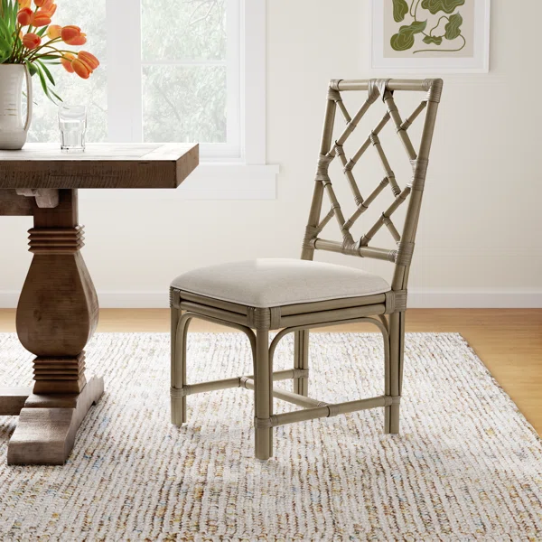 Wooden dining chair with a light cushioned seat beside a dining table.