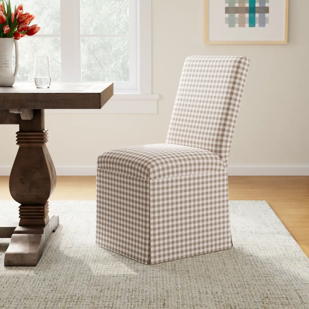 Skirted upholstered dining chair with a gingham pattern beside a wooden table.