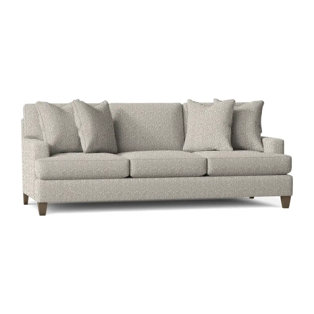 Light gray upholstered sofa with three seat cushions and four back pillows