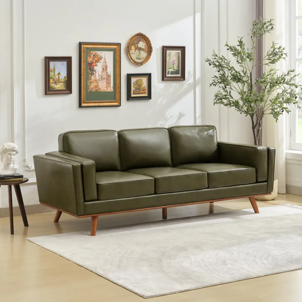 Olive‑green leather sofa with straight arms and wooden legs in a bright modern living room.