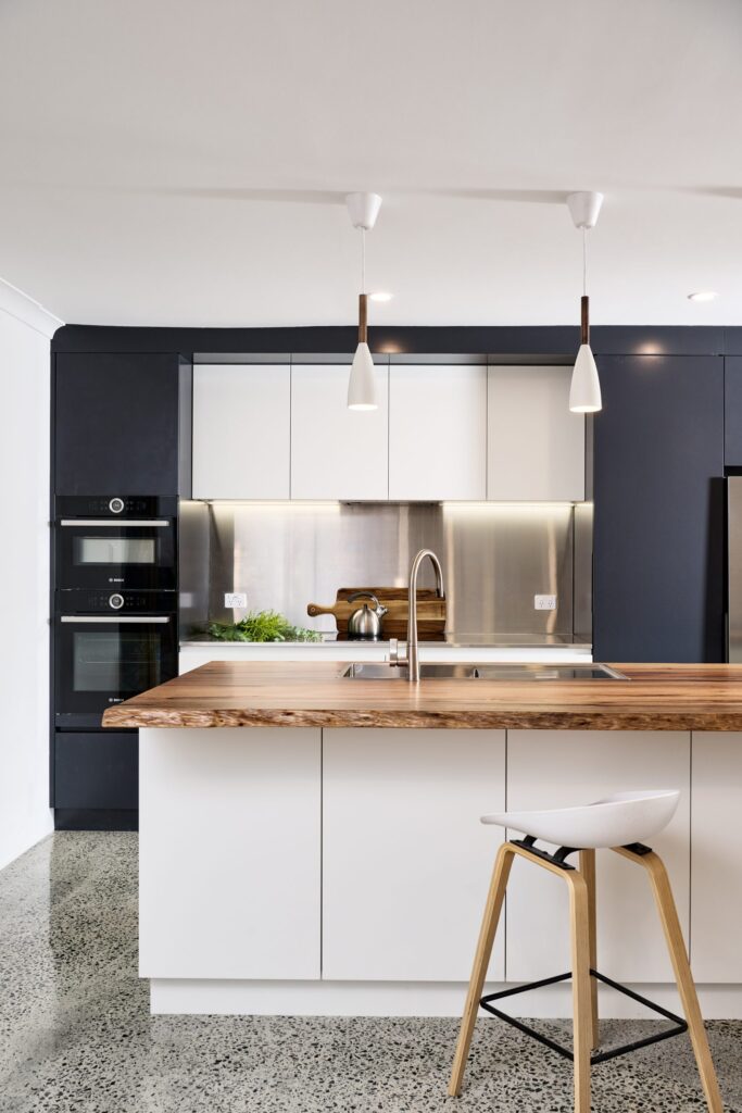 Kitchen with wooden cabinetry, a breakfast bar, and pendant lighting