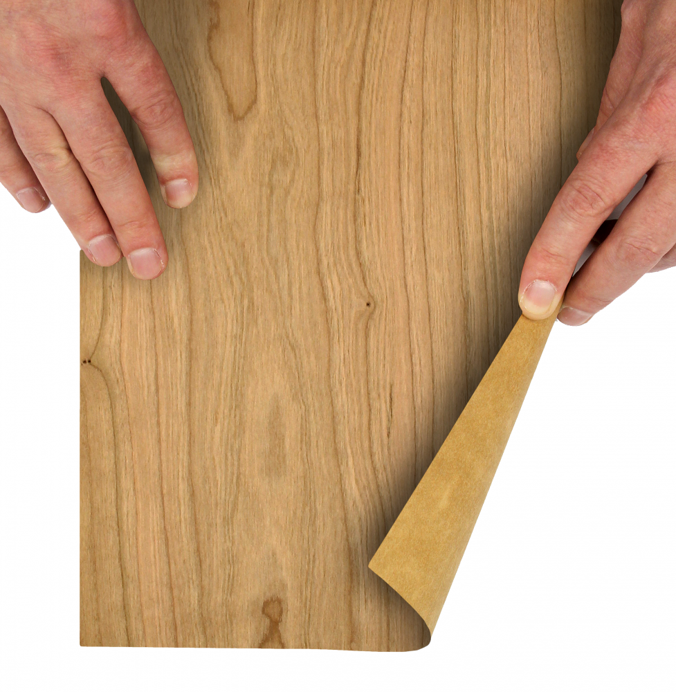 Hands peeling back a flexible cherry wood veneer sheet to show its grain and backing.