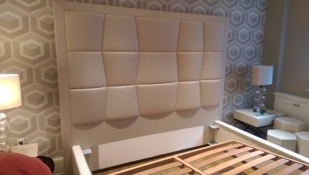 Completed bed frame with a padded geometric headboard installed in a furnished bedroom.